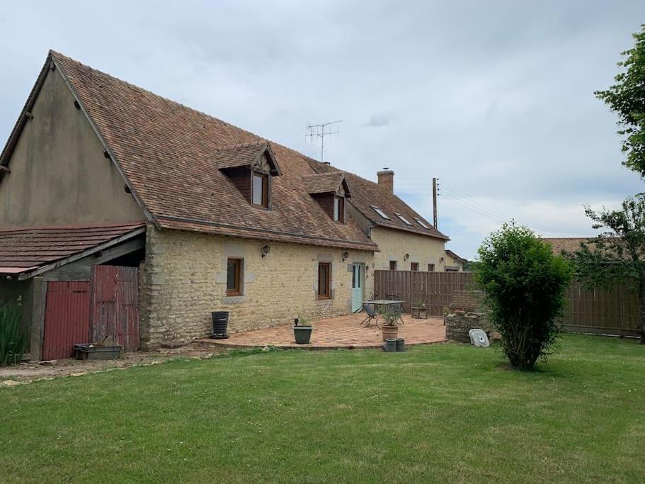 une vieille maison en briques avec une cour dotée d'une clôture dans l'établissement La petite Ballière, à Champfleur