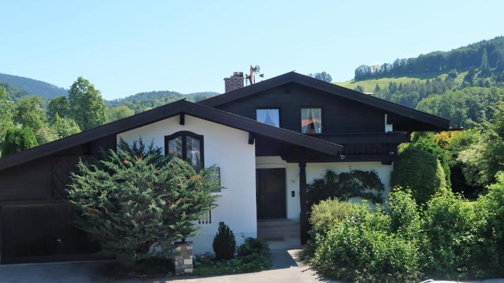 une maison blanche avec un toit noir dans l'établissement Ferienwohnung Zahnder inkl. Chiemgaukarte, à Ruhpolding