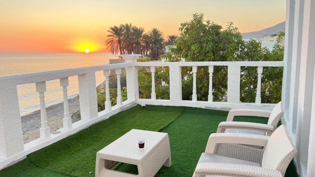 蘇爾的住宿－Wadi shab Rose Beach，一个带桌椅和海滩的阳台