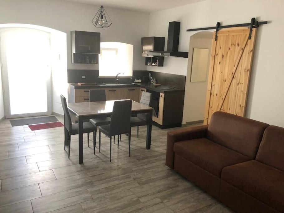 Una sala de estar con una mesa y sillas y un sofá. en Il nido vicino Castel di Sangro ed Alfedena, en Montenero Val Cocchiara