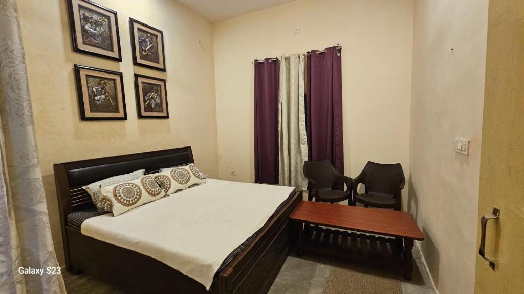 um quarto com uma cama, uma mesa e cadeiras em LDS Homestay em Ramnagar