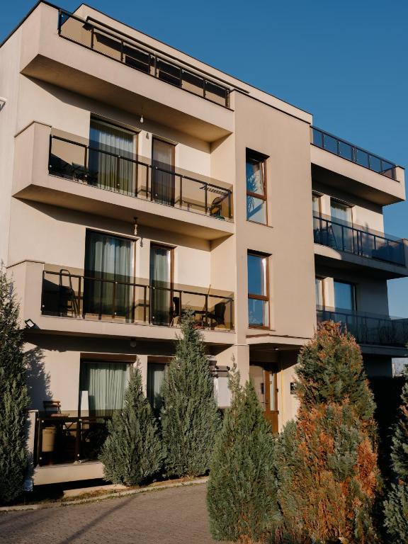 an apartment building with balconies and trees at Ionesco Apartments in Cluj-Napoca