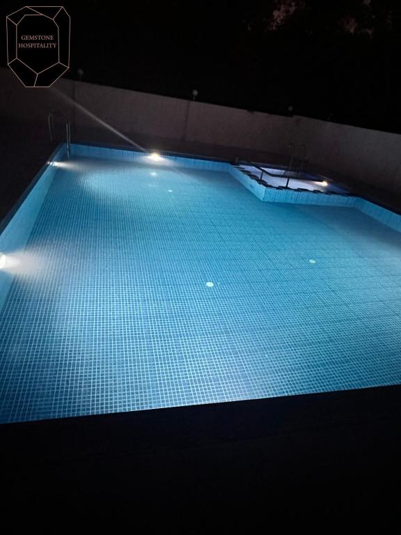 a large pool of blue water with lights in it at Golden Pearl Resort By Gemstone Hospitality in Alibag