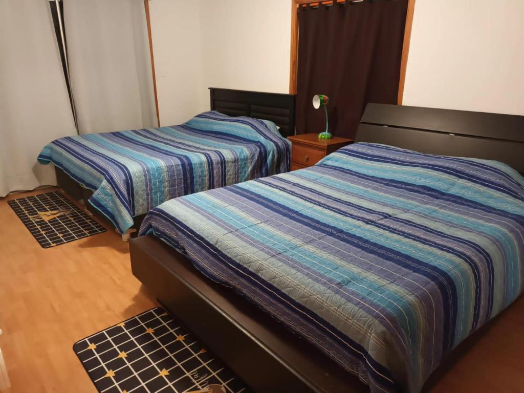Habitación pequeña con 2 camas en Hostal Al Yaras en Coquimbo