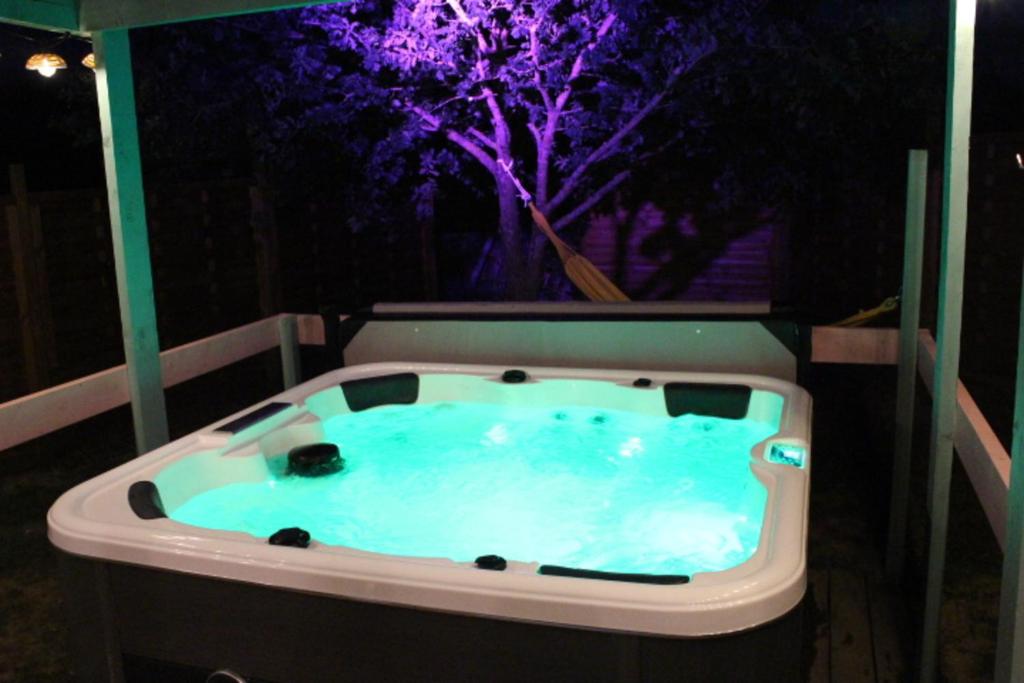 a jacuzzi tub with a tree in the background at CHALET CARAIBES SPA Privatif in Clermont-Créans