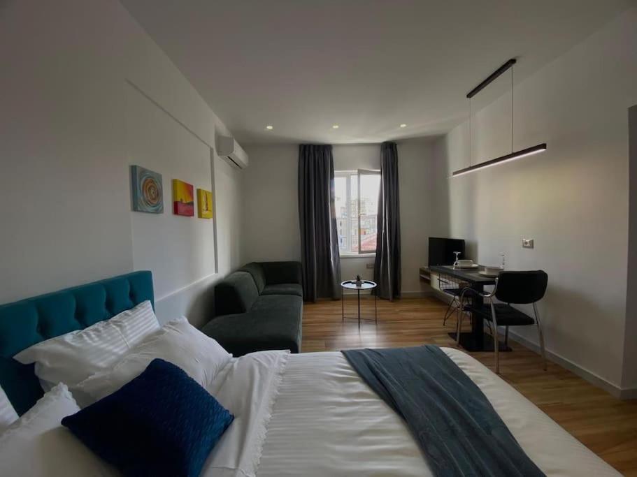 een slaapkamer met een bed, een bureau en een computer bij Tirana Elegant Apartment in Tirana