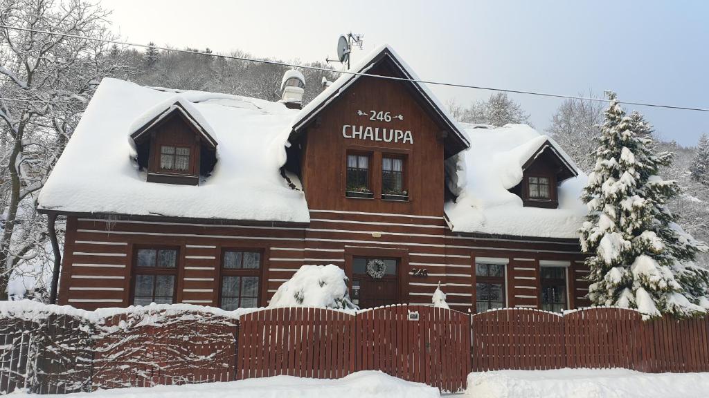 Cabaña de madera con nieve en el techo en Chalupa 246 en Vrchlabí