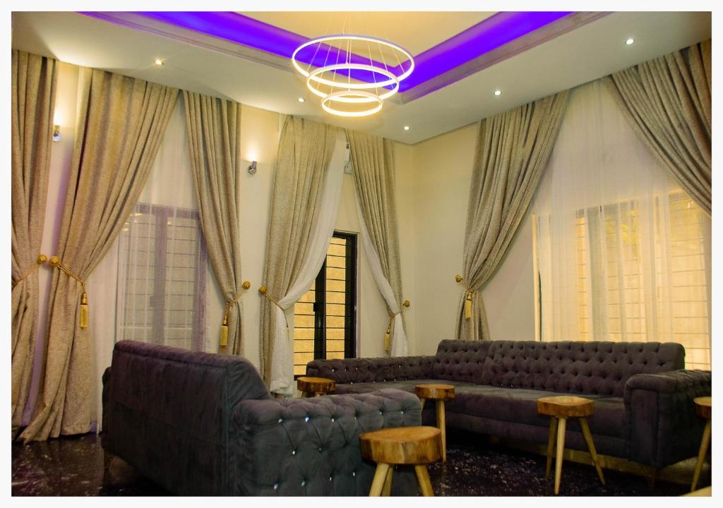 a living room with couches and tables and a purple lighting at House 7A in Enugu