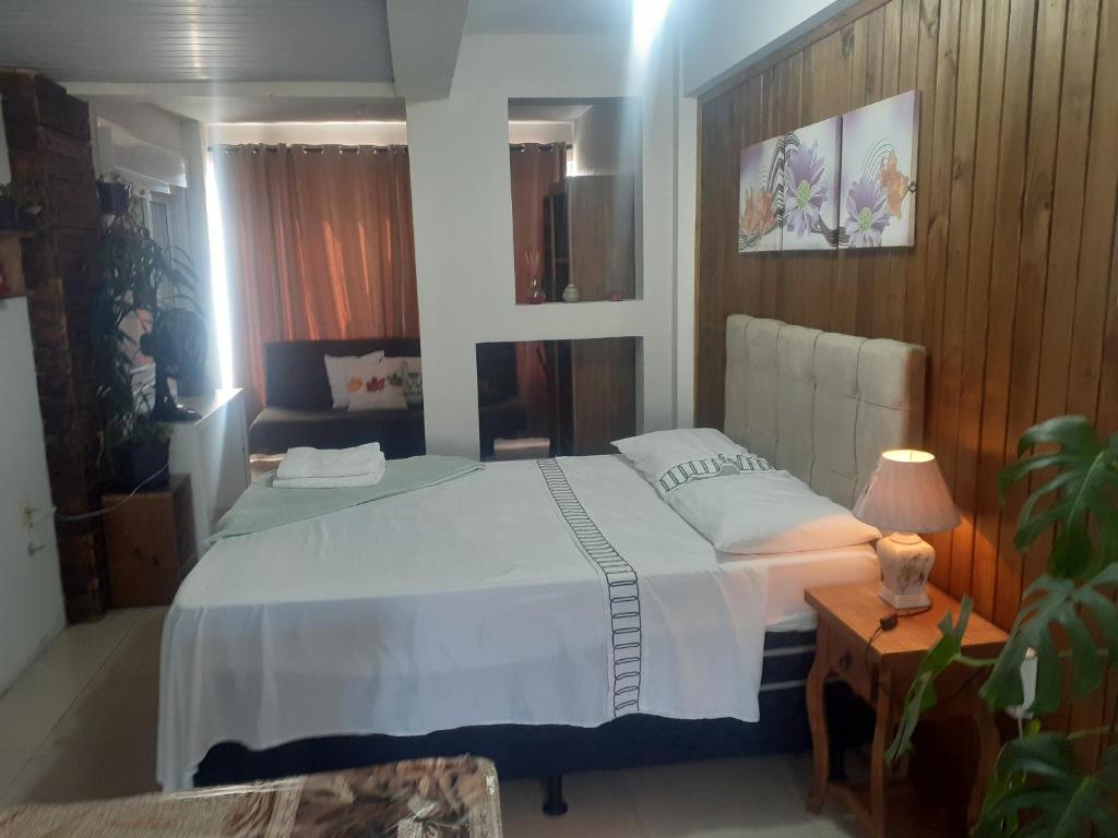 una camera con letto e tavolo con lampada di Loft conceito aberto - 4 pessoas a Araranguá