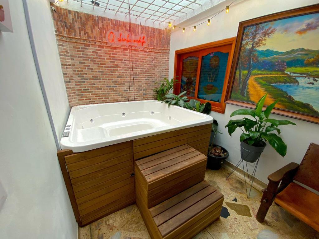 a large bath tub in a bathroom with a painting at Casa EstadioMed in Medellín