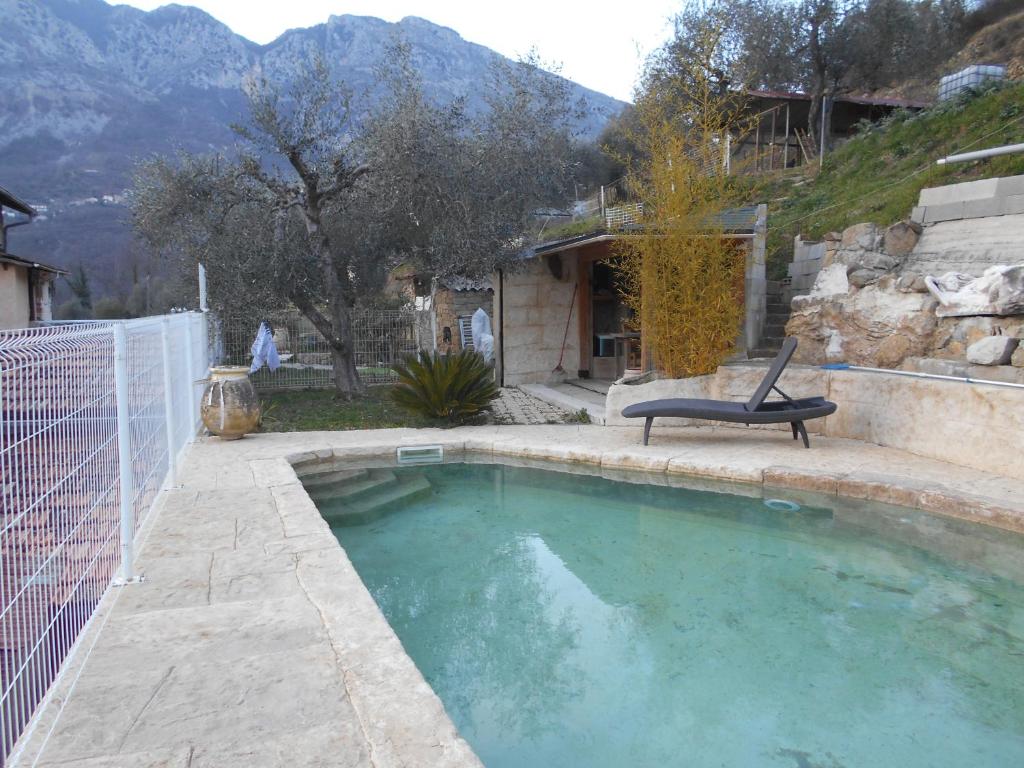 - une piscine avec une chaise à côté d'une maison dans l'établissement appartement independant avec piscine privee, à Lantosque