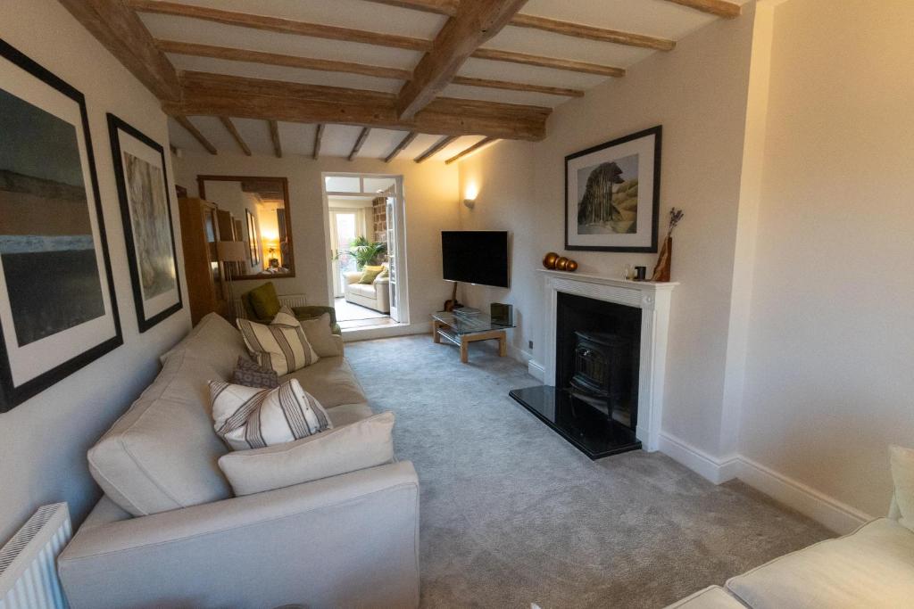 a living room with a couch and a fireplace at Oulton House - Beautiful Restored 2 Bedroom Property in Spofforth, Harrogate in Spofforth