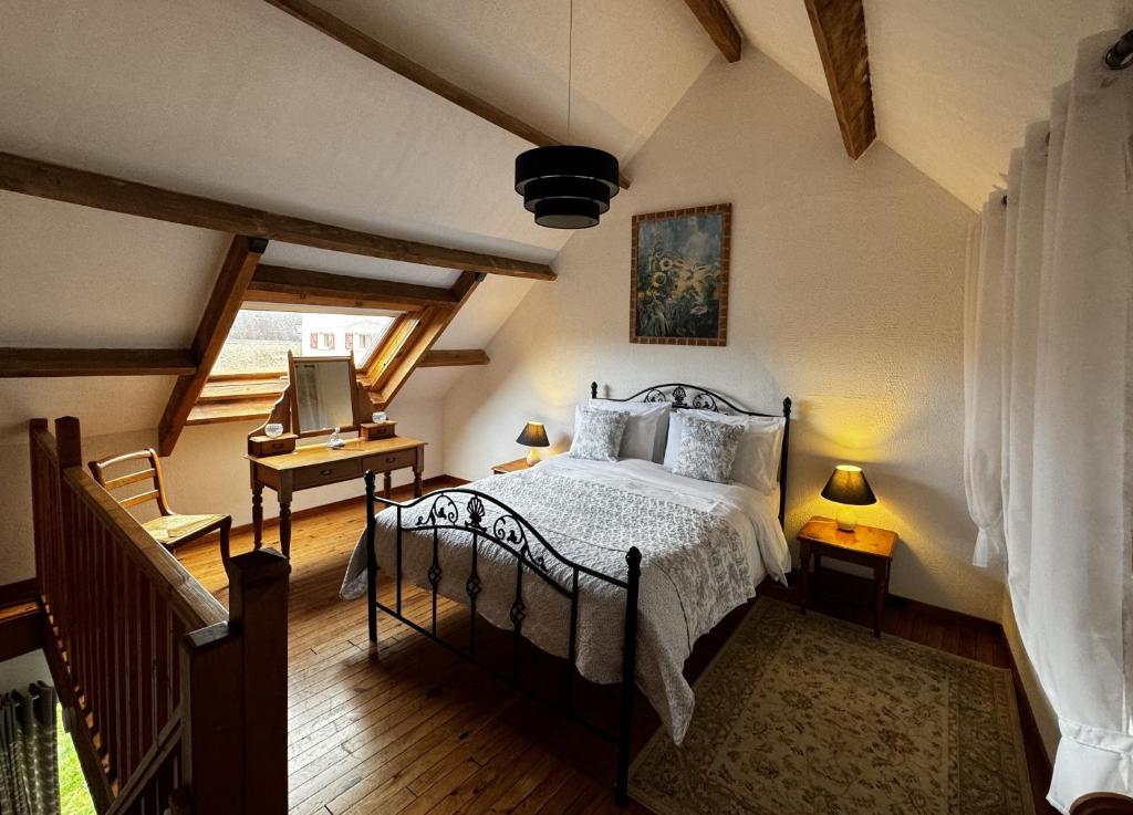 a bedroom with a bed and a table with a desk at Walnut Tree Gite Brittany in Boderel