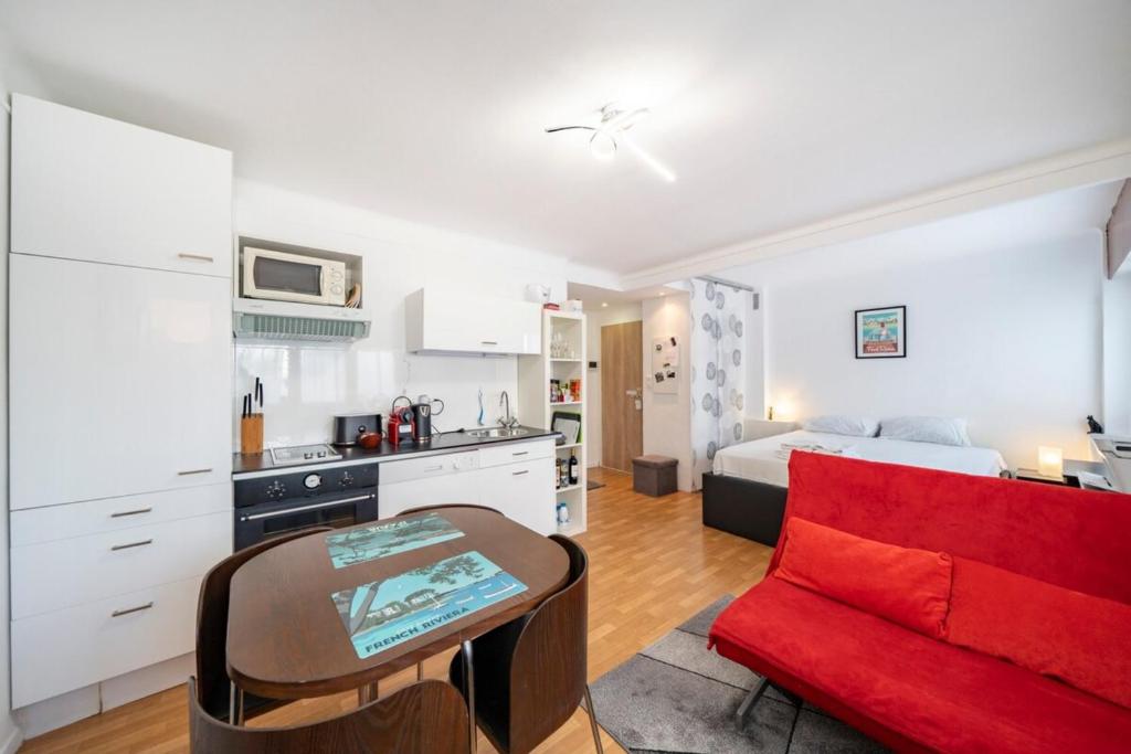 a kitchen and a living room with a red couch at Studio near beaches and Martinez in Cannes