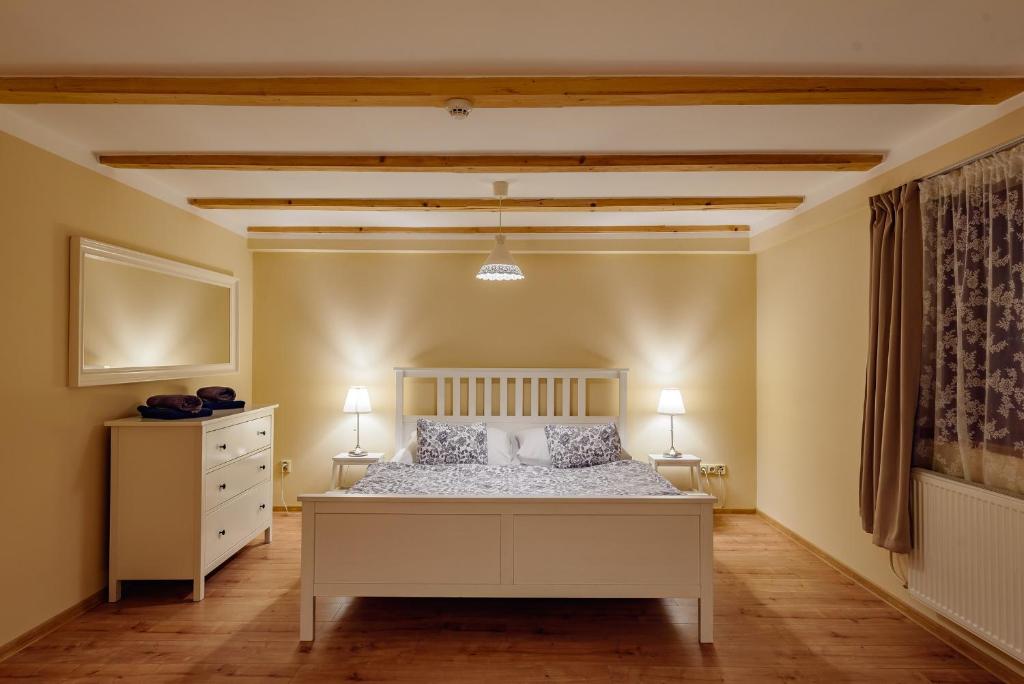 1 dormitorio con 1 cama blanca y 2 lámparas en Turciansky dvor - Apartmany Turiec, en Martin