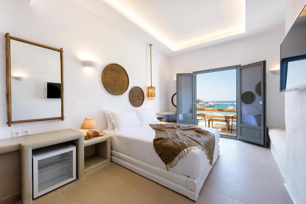 a bedroom with a bed and a view of the ocean at KIANO SUITES in Kampos Paros