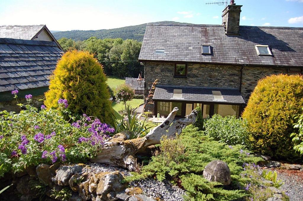 a garden with flowers in front of a house at Tre-Allt Gorgeous Cottage in Dolgellau