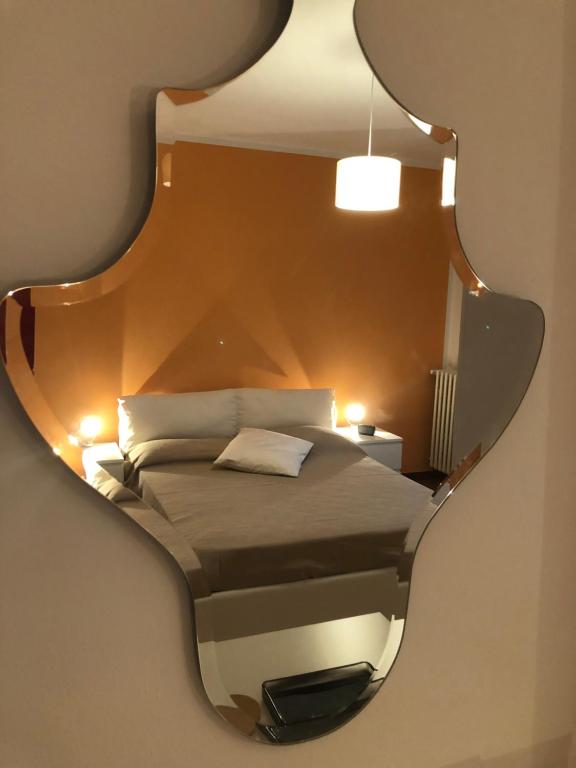 a bedroom with a bed in a mirror at [come a Casa] da Marina in Pieve Vergonte