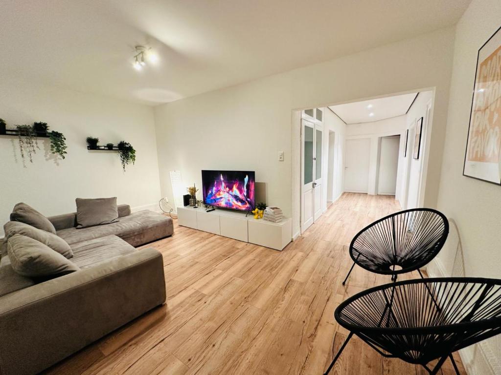 a living room with a couch and a flat screen tv at Exclusive apartment for families and business in Uster