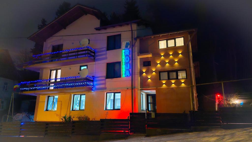 a building with lights on the side of it at night at Pensiunea Roua in Sinaia