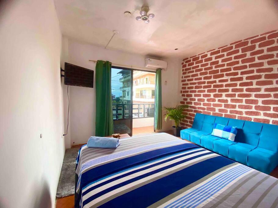 a bedroom with a blue couch and a brick wall at Suite céntrico vista al Mar in Montañita