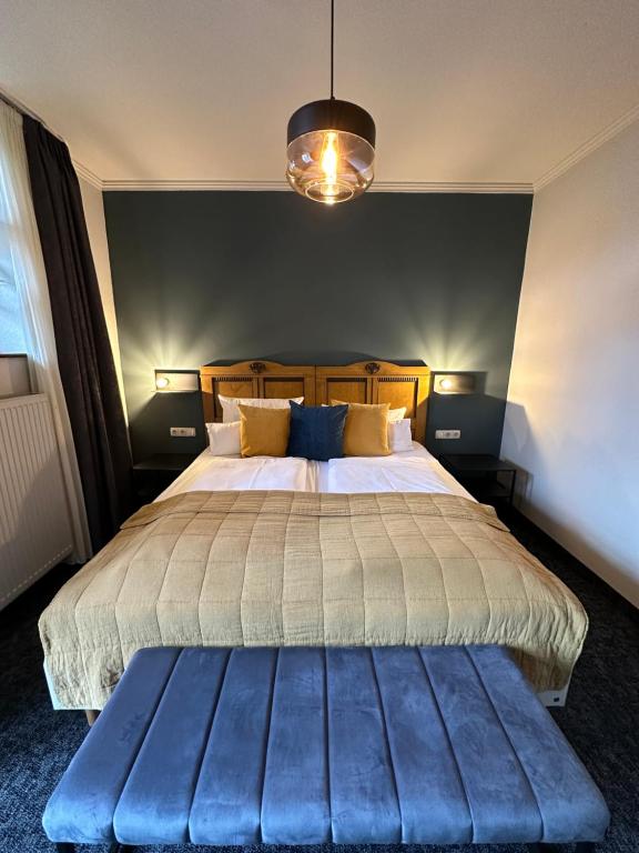 Schlafzimmer mit einem großen Bett und einer blauen Bank in der Unterkunft Gasthof zum Storch in Prichsenstadt