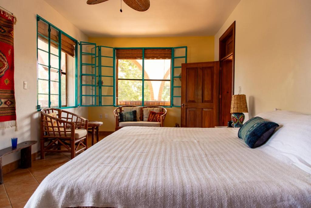 a bedroom with a bed and a table and chairs at Bombon Guesthouse in Brisas de Zicatela