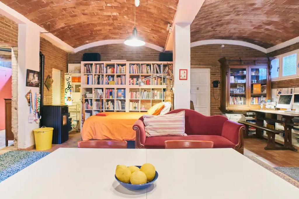 サン・クガ・デル・バリェスにあるLoft Art Studio Sant Cugat - Barcelonaのベッド1台、テーブル(フルーツボウル付)が備わる客室です。