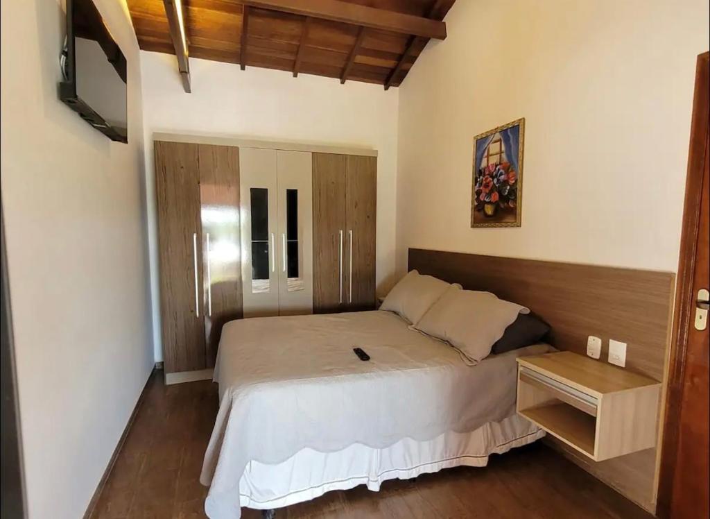 a bedroom with a large bed with a wooden headboard at Recanto NS Aparecida in Socorro