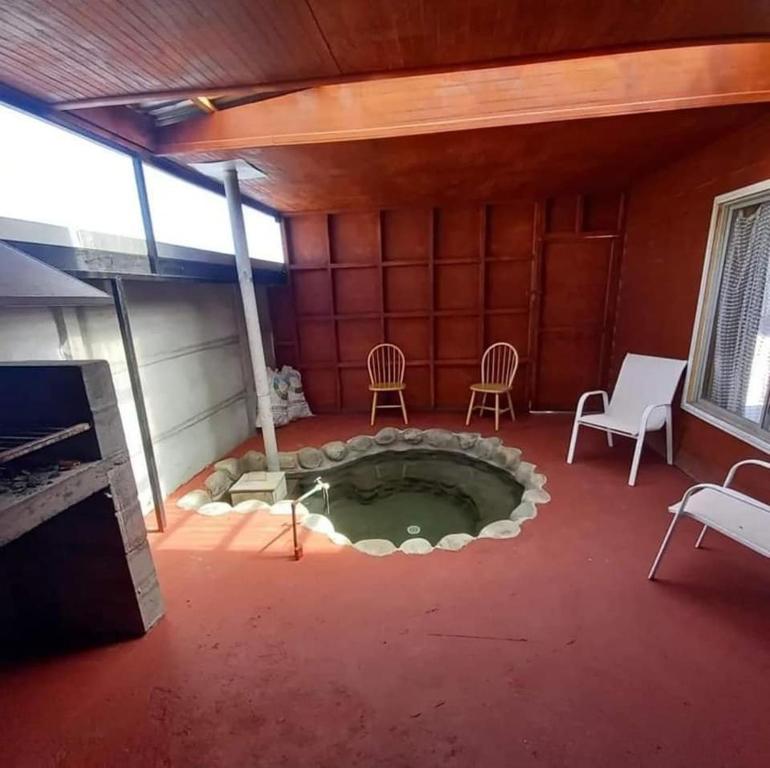 una habitación con una pequeña piscina en el centro de una casa en Cabañas con tinajas coronel, en Coronel