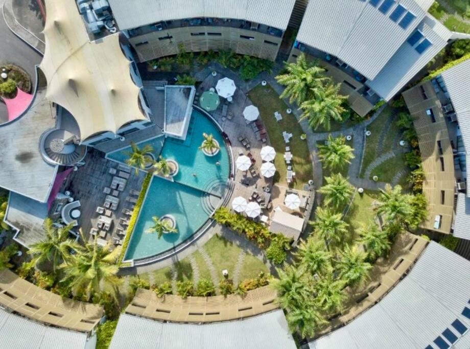 an aerial view of a resort with a pool and palm trees at Cosy studio - Trou-aux-Biches in Trou aux Biches