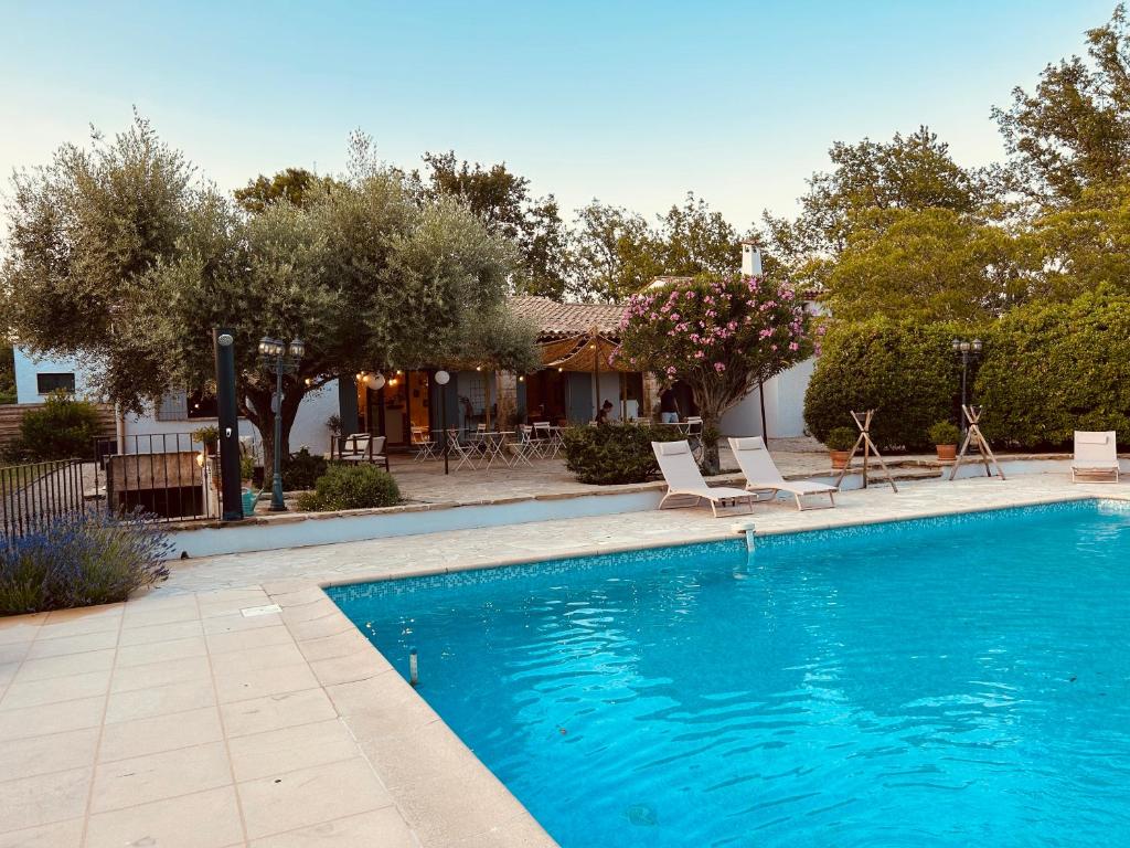 una piscina con due sedie e una casa di 4 Saisons en Provence a Saint-Paul-en-Forêt