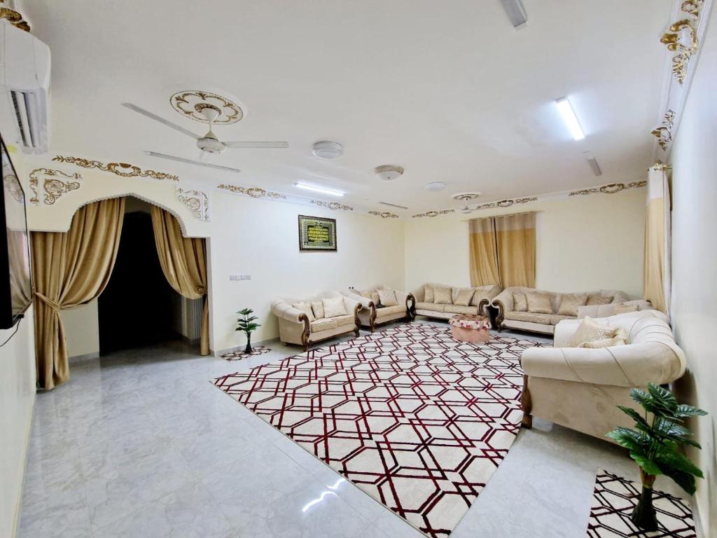 uma sala de estar com sofás e um tapete em Shakir house em Ibri