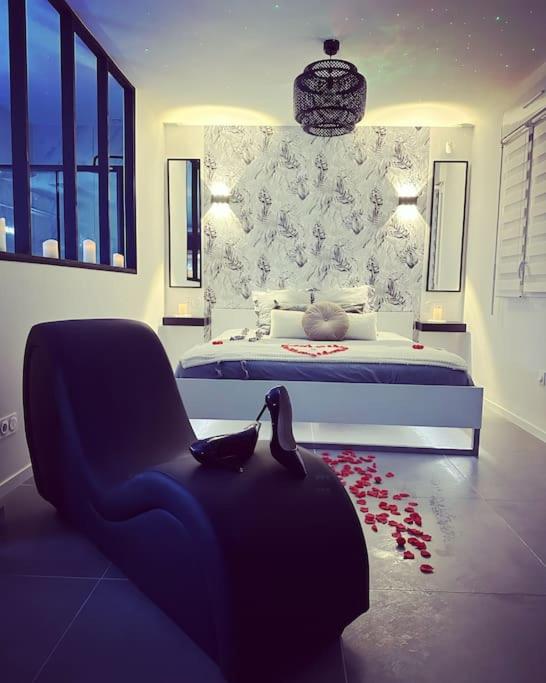 - une chambre avec un lit et un chat assis dans une chaise dans l'établissement Le Diamant Secret Love room gîte de charme romantique exceptionnel, à Marzan