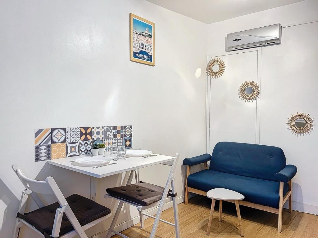 Cette chambre comprend une table et une chaise bleue. dans l'établissement L'Authentique Panier - Central & Calme - Les Frères de la Loc', à Marseille