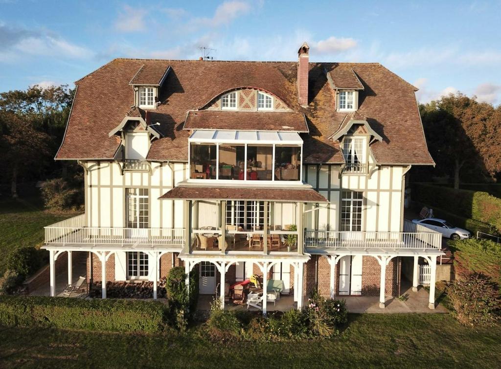 une grande maison blanche avec un toit dans l'établissement Appartement charmant à Hautot-sur-Mer, 45 m² avec stationnement, à Hautot-sur-Mer