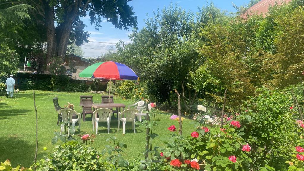シュリーナガルにあるZebervan Retreatの庭園のカラフルな傘を持つテーブル