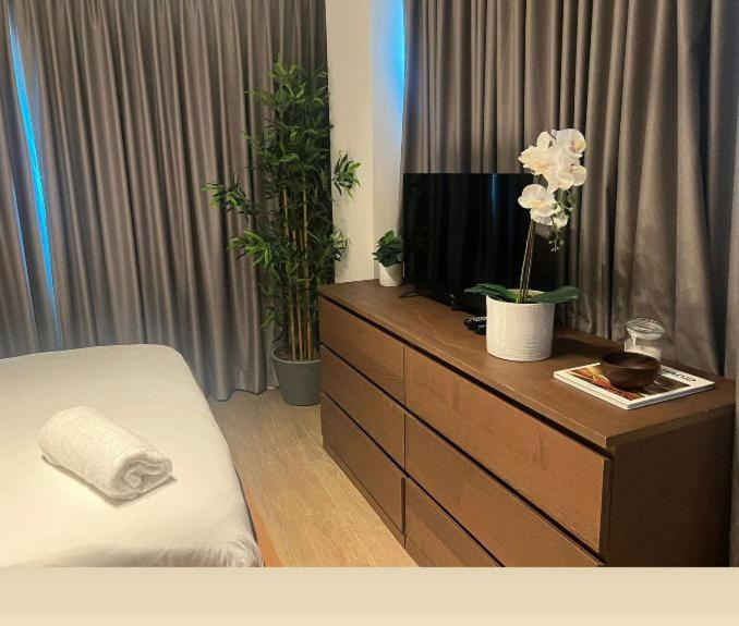 a bedroom with a dresser with a tv and plants at Hotel bienvenida in Los Tres Brazos