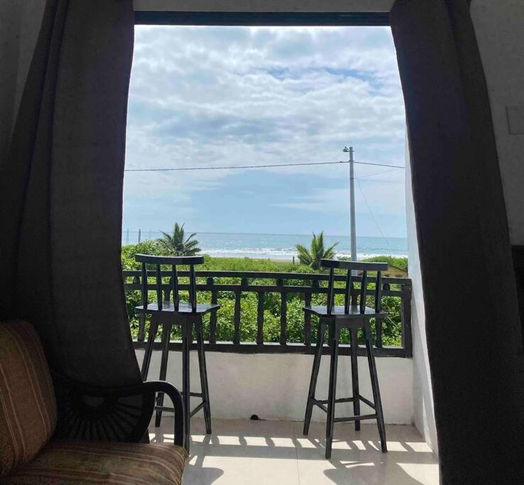 a balcony with two stools and a view of the ocean at Departamento vista al mar in Montañita