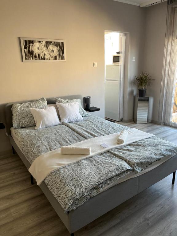 uma cama grande num quarto com um frigorífico em PV Apartman em Miskolc