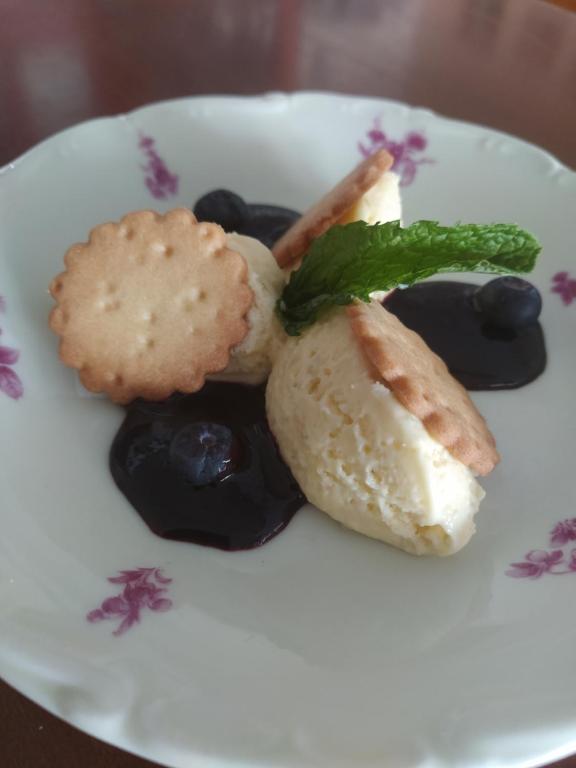 a white plate of food with cookies and blueberries at Hôtel restaurant Notre Dame in Orcival