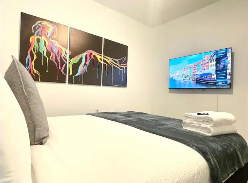 a bedroom with a bed with two paintings on the wall at Miami International Airport 2 in Miami