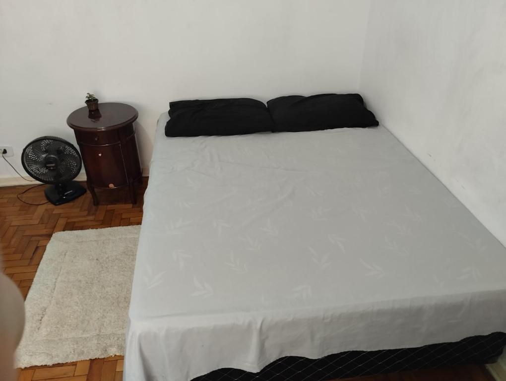 białe łóżko z czarnym zagłówkiem w pokoju w obiekcie Aphostel compartilhado gatinhos perças w mieście Santos