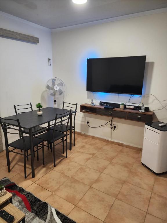 una sala da pranzo con tavolo e TV a schermo piatto di Maria a Rio do Ouro