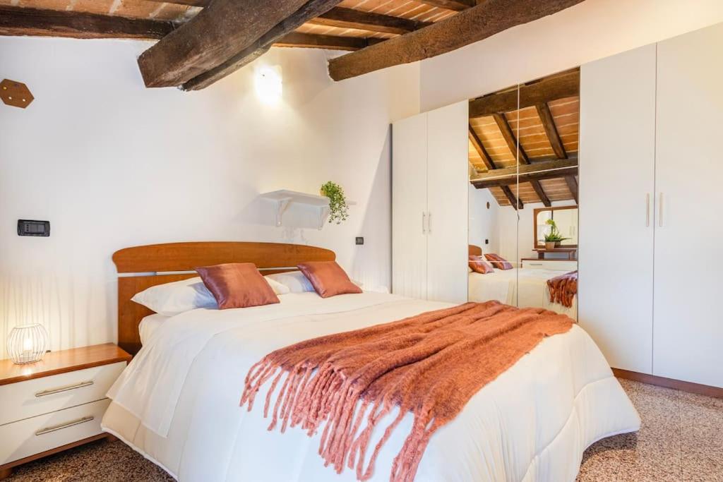 1 dormitorio con 1 cama blanca con manta marrón en Ferrari Museum & Train Station - Il Cavallino Loft, en Módena