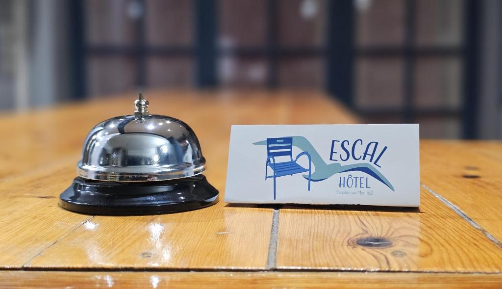 un casco de plata sentado en una mesa junto a una señal en Escal Hôtel en Étaples