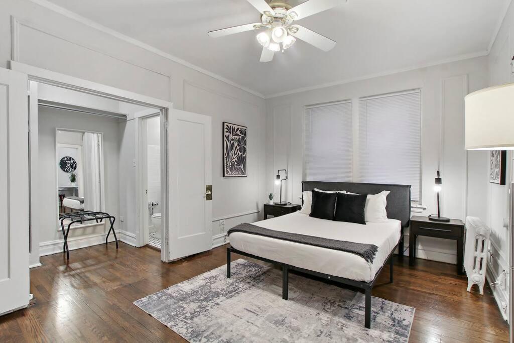 a white bedroom with a bed and a ceiling fan at Modern Minimalist Studio Haven - Bstone 105 and 108 rep in Chicago