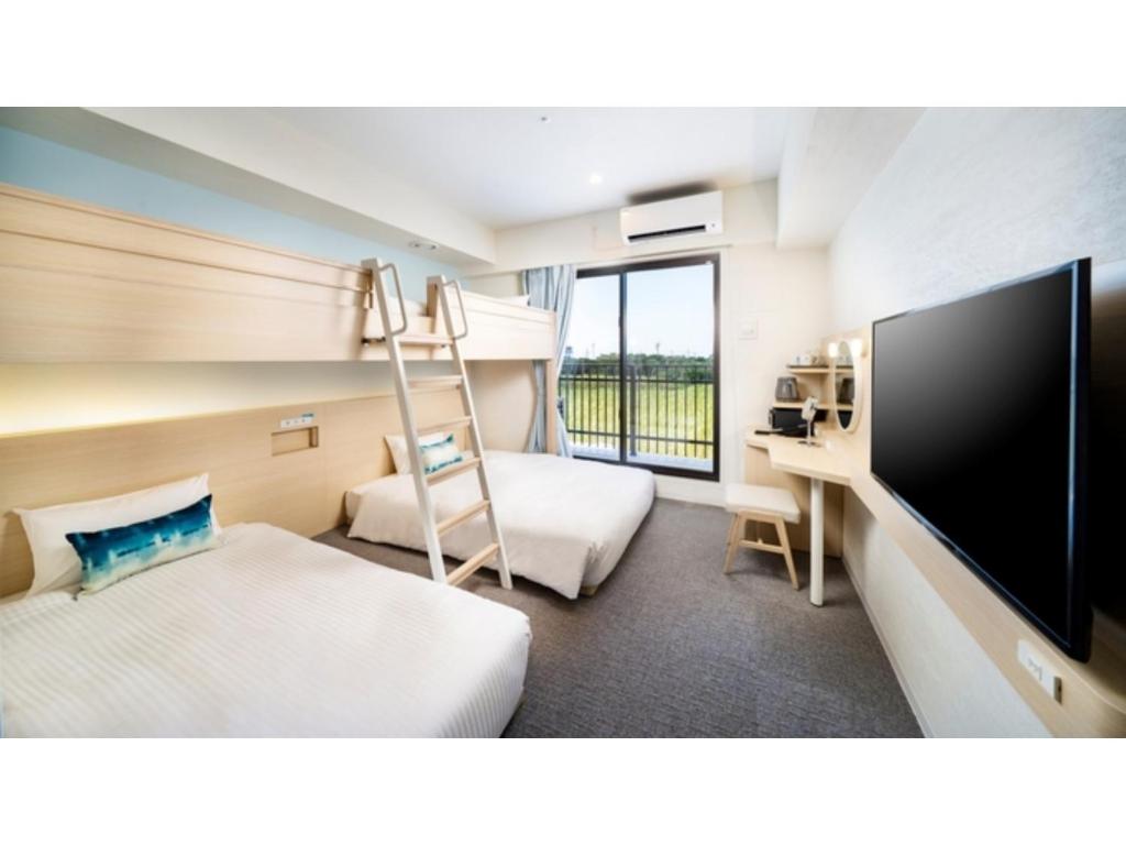 a hotel room with a bunk bed and a television at Hotel Torifito Miyakojima Resort - Vacation STAY 79480v in Miyako Island