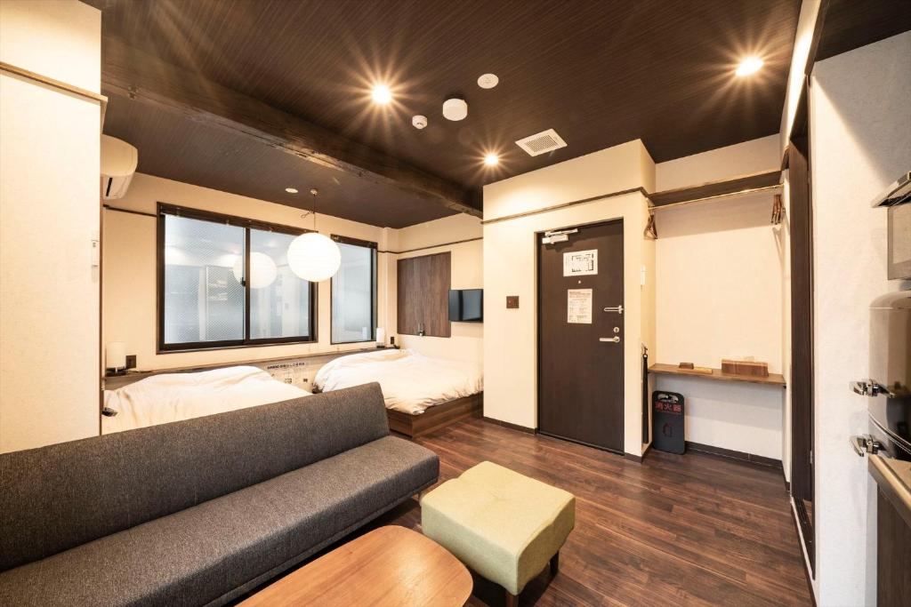 salon z kanapą i łóżkiem w obiekcie Kobe Motomachi Roji Building - Vacation STAY 16195 w mieście Kobe
