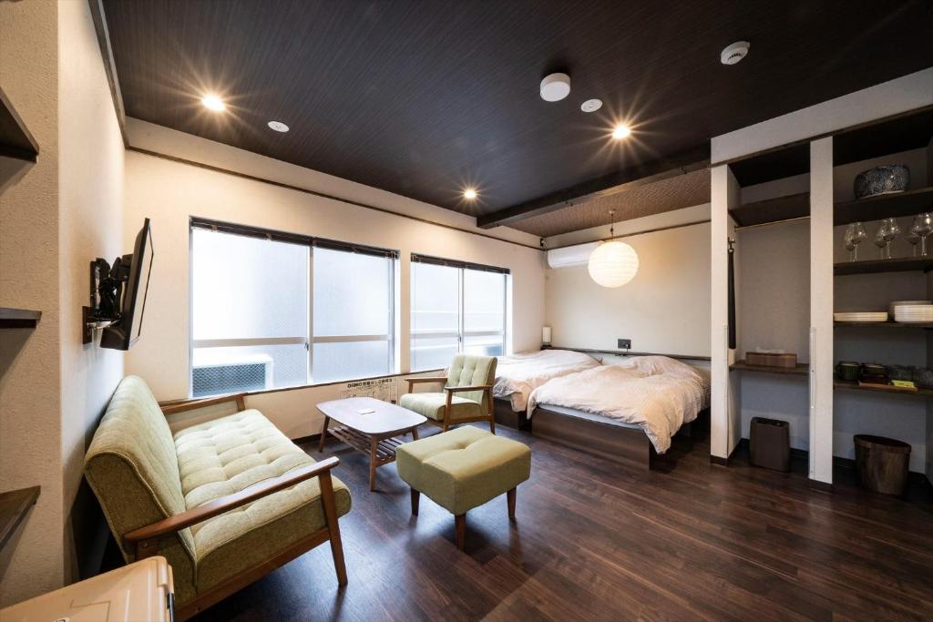 Kobe Motomachi Roji Building - Vacation STAY 16197 في كوبه: غرفة نوم بسرير واريكة وطاولة
